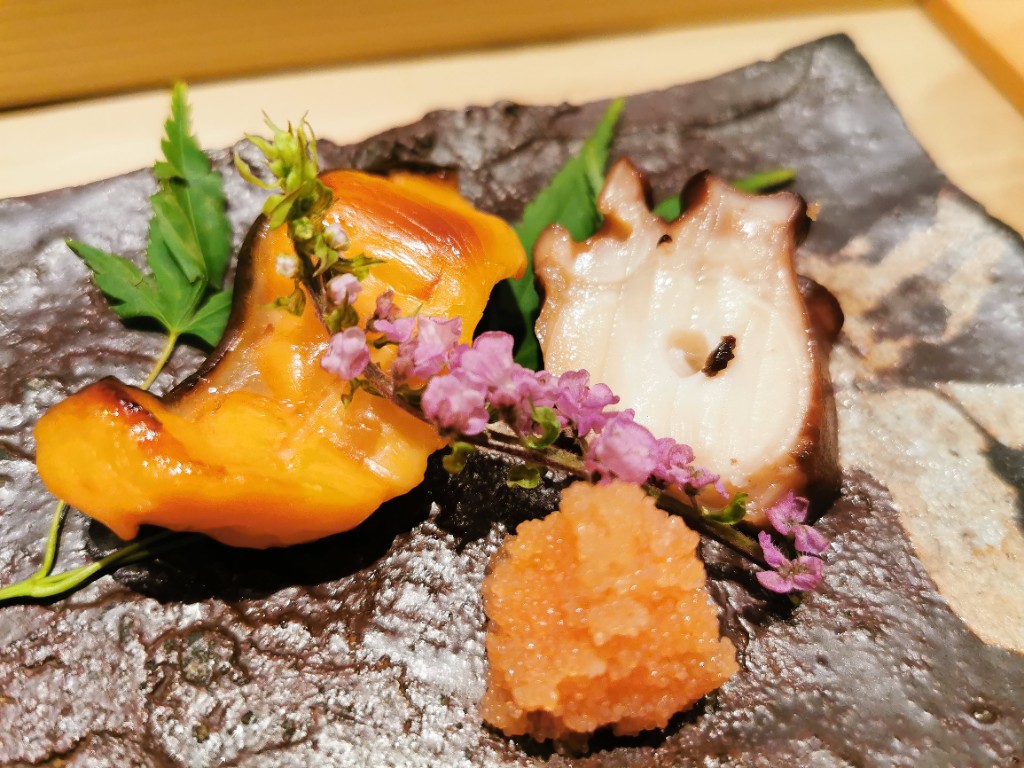 雲丹・蛸・明太子の前菜盛り。黒い石皿に紫の花あしらい
